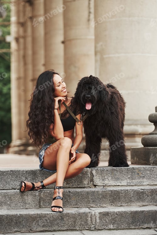 Preview: Beautiful woman with curly black hair have good time in the city at daytime