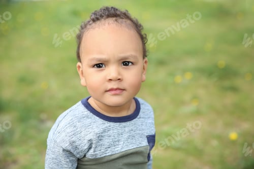Preview: Cute African-American baby in stylish clothes posing outdoors