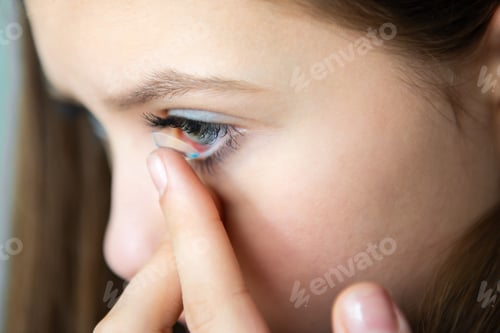 Preview: Close-up of a girl holding contact lenses on her finger and applying them to her eye,