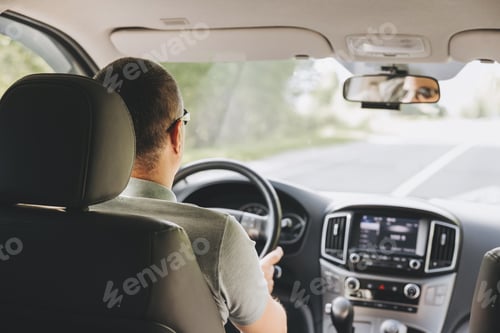 Preview: Young man holding steering wheel while driving car. Road trip adventure
