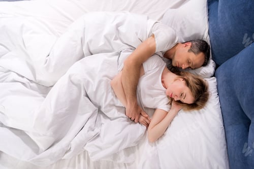 Preview: overhead view of couple sleeping in bed at home