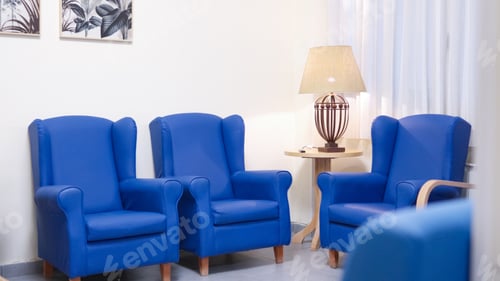Preview: Empty blue armchairs in modern nursing home lounge