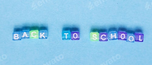 Preview: The inscription back to school made by multicolor plastic cubes on a blue background.