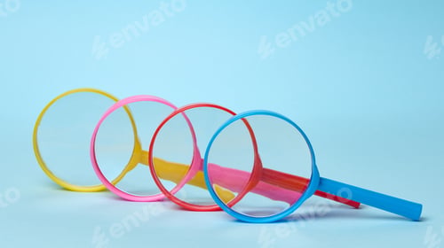 Preview: Multicolored plastic magnifying glasses on a blue background