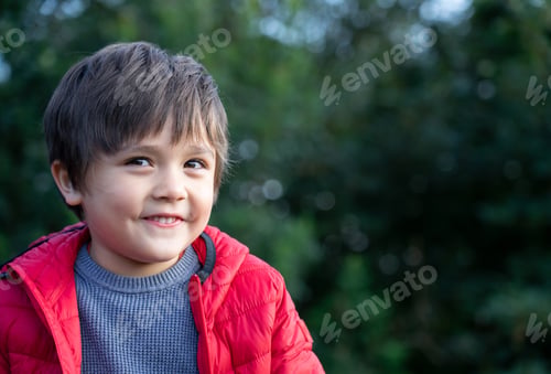 Preview: kid looking at camera and smiling face. boy relaxing outside the park,Child playing outdoor