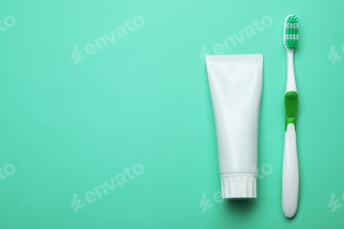 Preview: Blank tube of toothpaste and brush on color background, top view with space for text