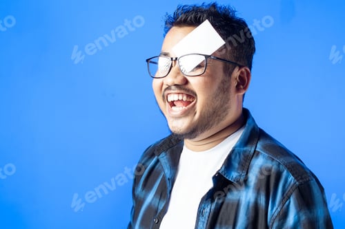 Preview: cheerful man wearing glasses and covering his eye with paper card