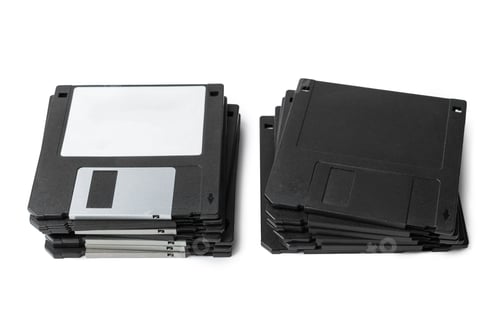 Preview: Collection of old floppy disks stacked on a white background for storage and nostalgia
