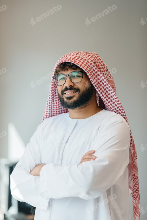 Preview: Arab businessman smiling, crossing arms in office