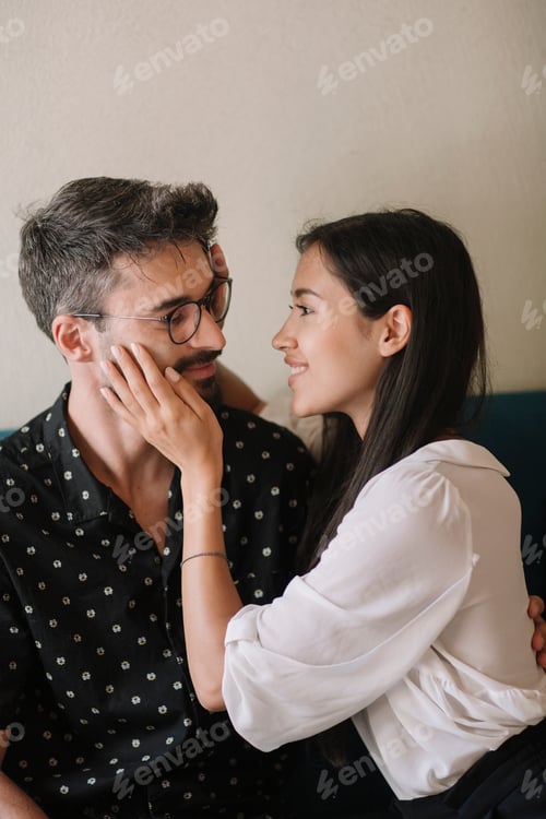 Visualização: Jovem casal apaixonado abraçando em um sofá