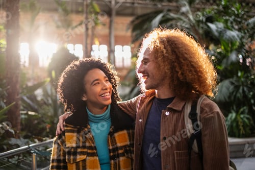 Preview: Happy tourist couple walking and smiling in atocha train station, madrid