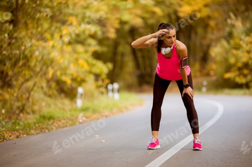 Preview: Young woman have a break during training in the autumn forest