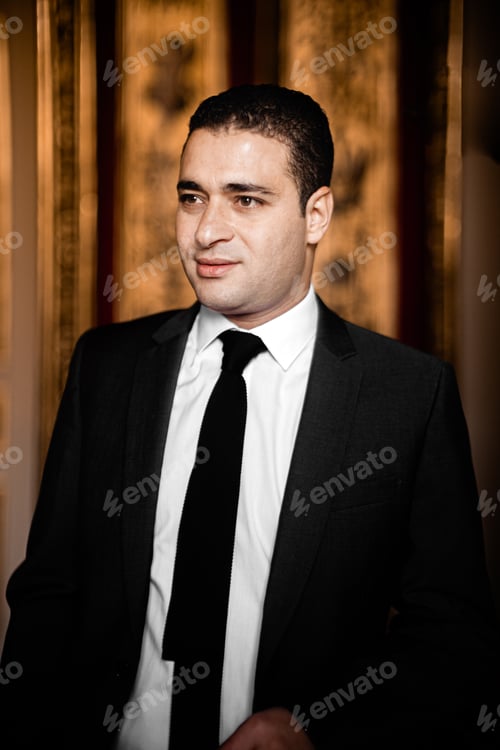 Preview: Young man wearing a black suit and black tie