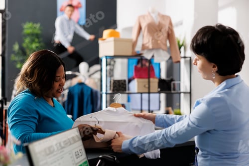 Preview: Woman giving multiple shirts to worker