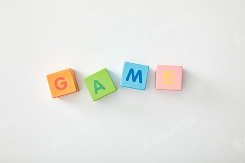 Preview: top view of game lettering made of multicolored cubes on grey background