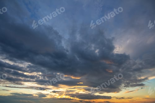 Preview: Blue sunset sky covered with white puffy clouds.