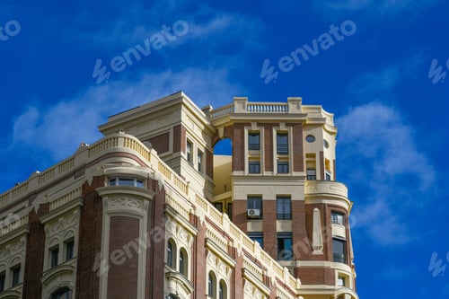 Preview: Low-angle shot of a beautiful architectural building under a blue sky with clouds in Madrid, Spain.