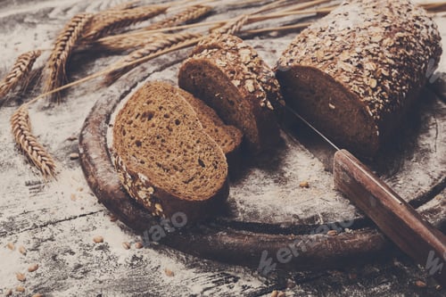Preview: Bakery concept background. Whole grain sliced bread and knife