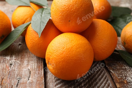 Preview: Fresh oranges and leaves on wooden table, closeup