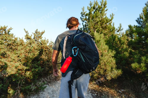 Preview: Portrait of hiker man with backpack trekking in the mountains