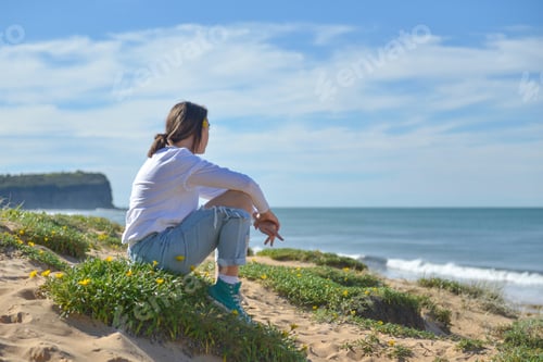 Preview: Teenager looking out across the water deep in thought, alone in meditation