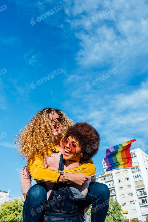 Preview: Two women friends hanging out in the city waving LGBT in Madrid city