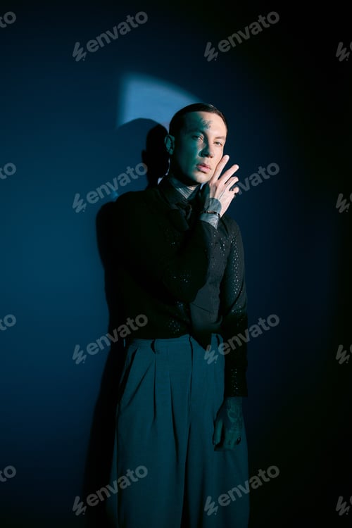 Preview: Handsome young man showcasing unique fashion in an artistic and moody setting