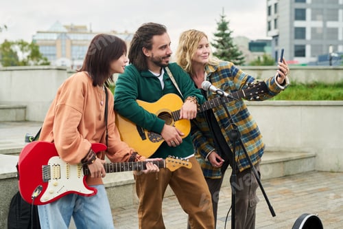 Preview: Group of Young Adult Musicians Performing Outdoors and Taking Selfie Together