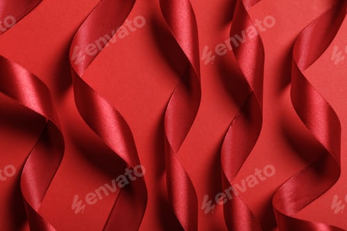 Preview: close up of wavy silk red ribbons on red background