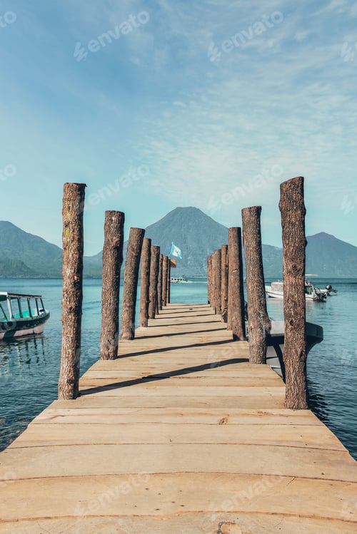 Preview: Vertical closeup shot of a pier on the lake with mountains on the background