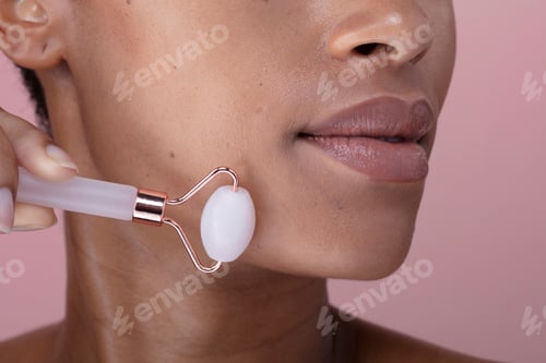 Preview: Close-up of woman using facial roller