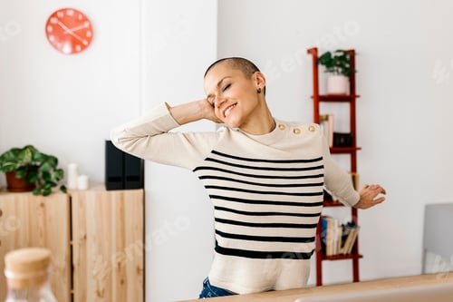 Preview: Young businesswoman stretching at home office workplace
