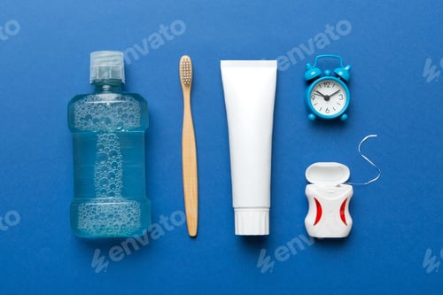 Preview: Mouthwash and other oral hygiene products on colored table top view with copy space