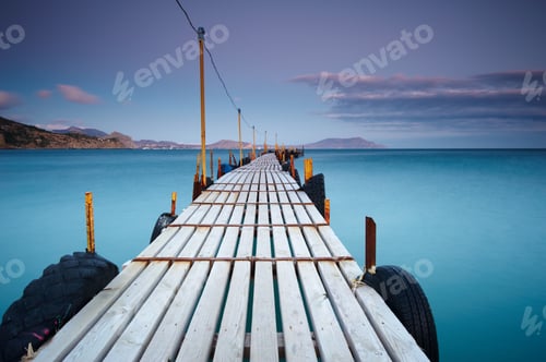 Preview: Wooden jetty on sea sunset and sky reflection water.