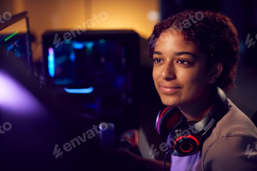 Preview: Teenage Girl With Headset Gaming At Home Using Dual Computer Screens