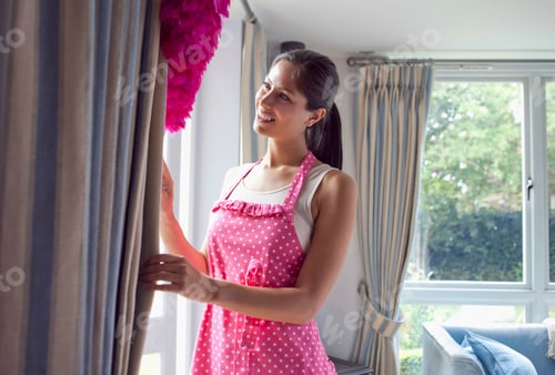 Preview: Woman dusting curtains in living room