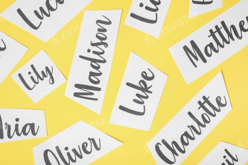 Preview: Paper sheets with written different baby names on yellow background, flat lay