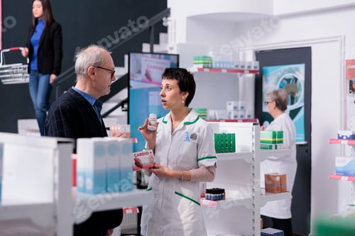Preview: Medical employee showing customer heart pills and giving recommendations