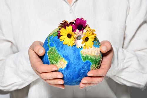 Preview: Woman holding handmade Earth model with flowers