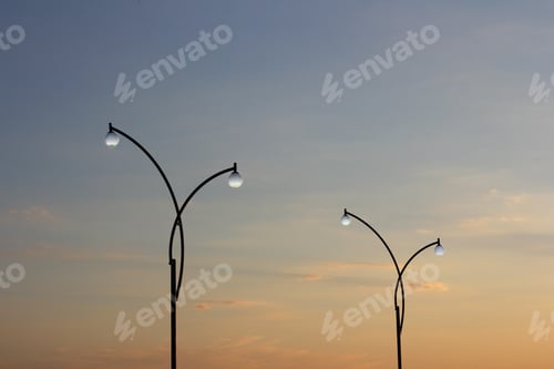 Preview: Two street lamp agains a sunset sky