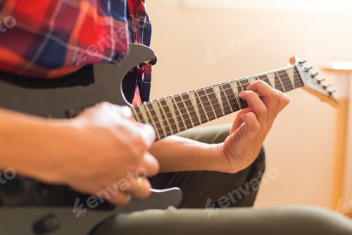 Preview: Millennial man playing, practicing electric guitar at home