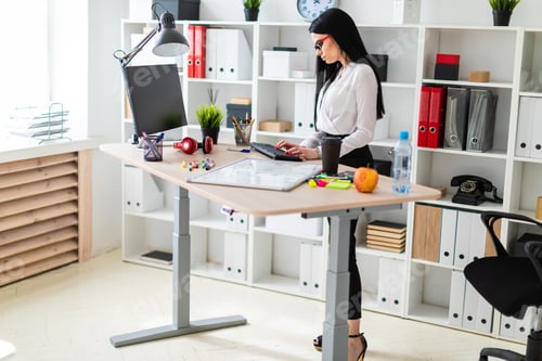 Preview: A young girl stands near a table and prints on the keyboard. Before the girl is a magnetic board and