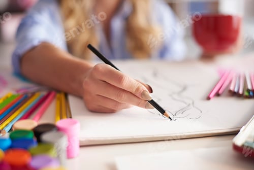 Preview: Woman drawing sketches in the book
