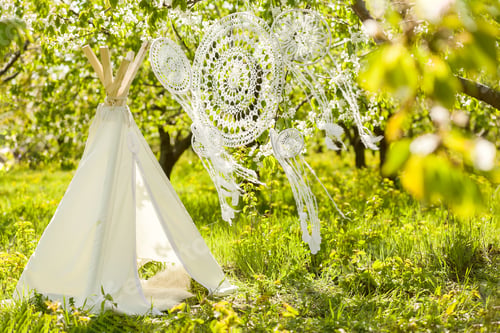 Preview: Wigwam and crocheted dream catchers in a spring blooming garden