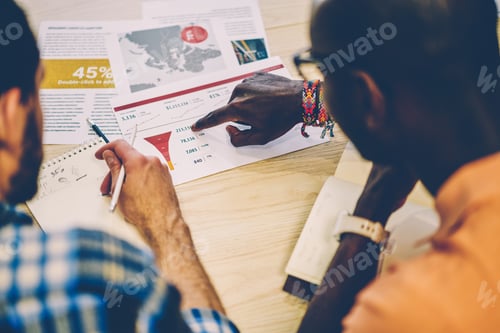 Preview: Diverse men reading documents together in workplace