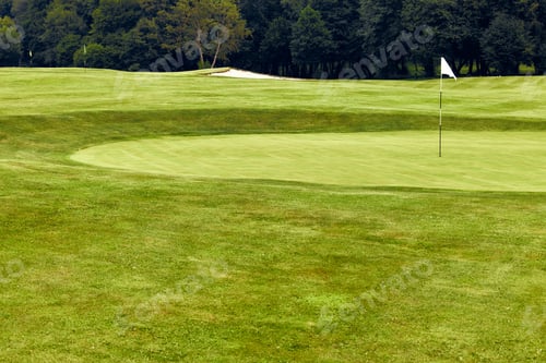 Preview: A Stunningly Beautiful Golf Course Green Complete with a Flag Surrounded by Lush Landscape