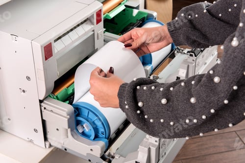 Preview: Woman adjusting a roll of new photo paper