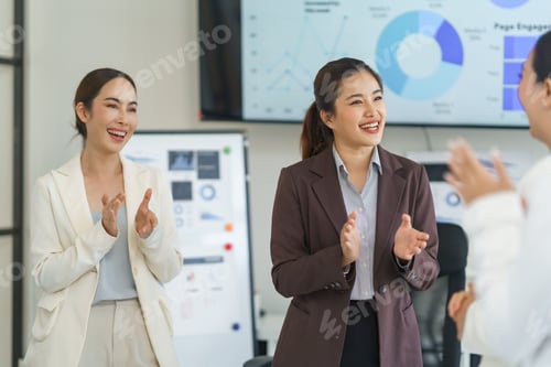 Preview: Businesswomen clapping hands celebrating successful project during meeting in office
