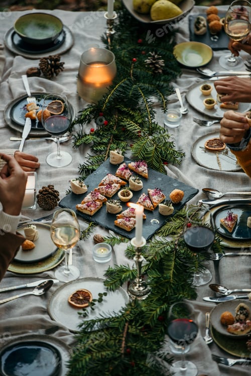 Preview: Friends celebrating christmas dinner with festive food, wine, and candles