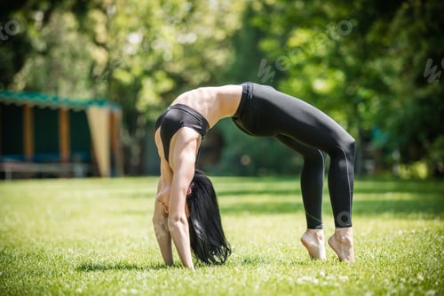 Preview: Young woman performing bridge exercise in park